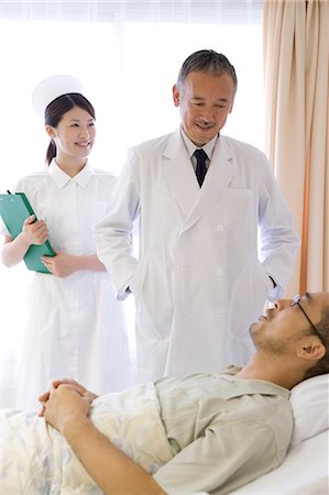 simsearch:685-02938374,k - Doctor and nurse talking to patient in bed Stock Photo - Premium Royalty-Free, Code: 685-02938365