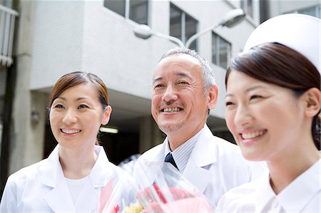 simsearch:685-02938374,k - Doctors and nurse giving bunch of flowers Stock Photo - Premium Royalty-Free, Code: 685-02938404