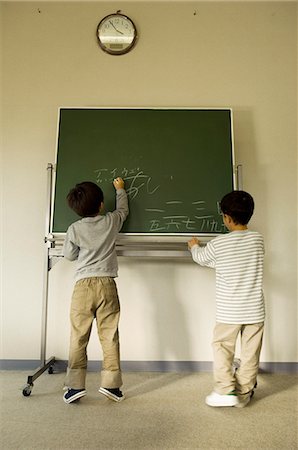 Boys writing on blackboard Stock Photo - Premium Royalty-Free, Code: 685-02938780