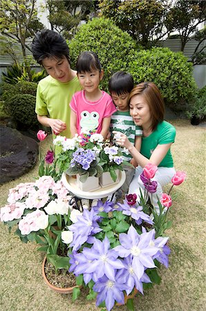 flower for mom asian - Family looking at flower in garden Stock Photo - Premium Royalty-Free, Code: 685-02940607