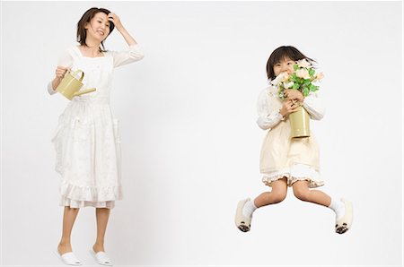 flower for mom asian - Girl holding flower and mother holding watering can Stock Photo - Premium Royalty-Free, Code: 685-02942062