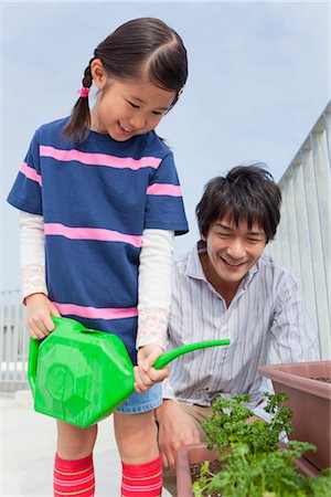 Father and daughter watering plant Stock Photo - Premium Royalty-Free, Code: 685-03082728