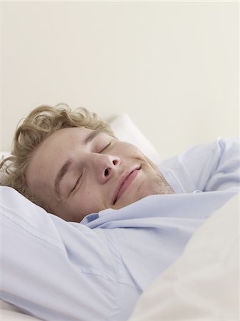 satisfacción - Young man lying in bed Foto de stock - Sin royalties Premium, Código: 689-05610128