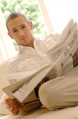 simsearch:689-05610302,k - Young man reading newspaper on couch Foto de stock - Sin royalties Premium, Código: 689-05610280