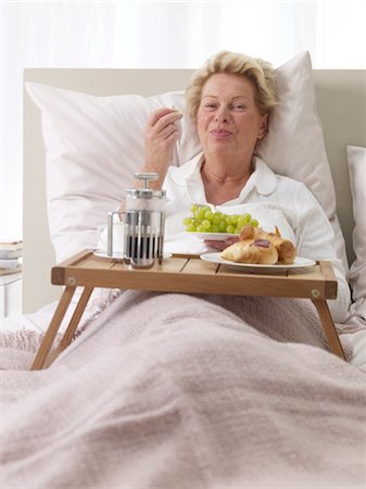 eating happy people 50 - Woman having breakfast in bed Stock Photo - Premium Royalty-Free, Code: 689-05612725