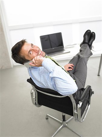 Telephoning business man having his legs on his desk Stock Photo - Premium Royalty-Free, Code: 689-03125916