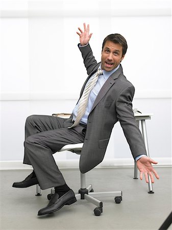Business man sitting on a chair makes a gesture Stock Photo - Premium Royalty-Free, Code: 689-03125917