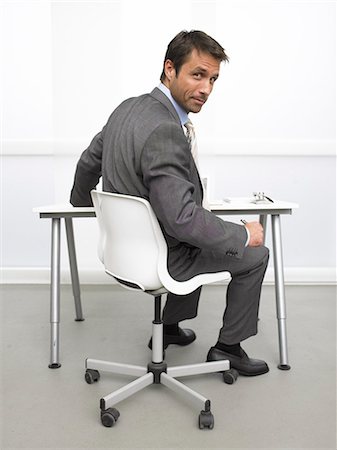 Business man at his desk is looking back Stock Photo - Premium Royalty-Free, Code: 689-03125920