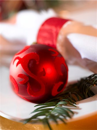 Place cover with a white napkin,a red Christmas tree ball and a fir branch Stock Photo - Premium Royalty-Free, Code: 689-03126199