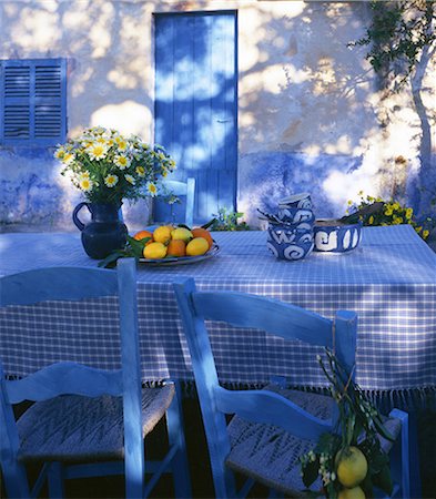 Blue and white table with lemons and oranges and a bouquet of marguerites Stock Photo - Premium Royalty-Free, Code: 689-03130399