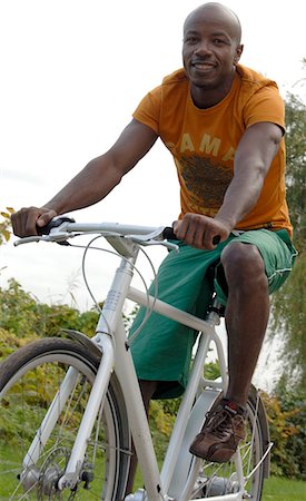 African on white bicycle Stock Photo - Premium Royalty-Free, Code: 689-03130932