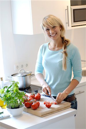 Woman slicing tomatoes in kitchen Stock Photo - Premium Royalty-Free, Code: 689-03733167