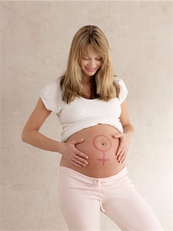 Pregnant woman with female symbol on stomach Stock Photo - Premium Royalty-Free, Code: 689-03733175
