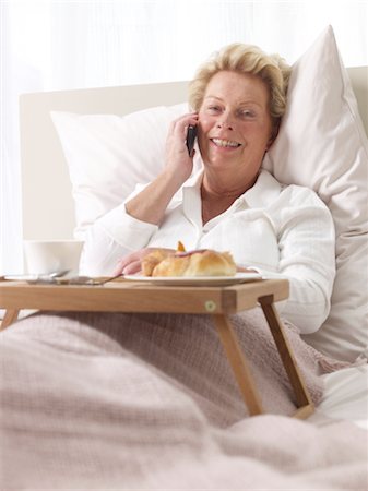 simsearch:689-03733616,k - Woman on cell phone having breakfast in bed Stock Photo - Premium Royalty-Free, Code: 689-03733816