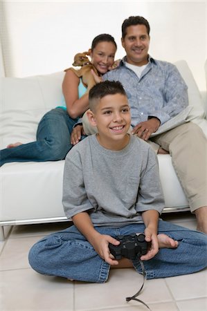 simsearch:693-06013834,k - Parents Watching Son Play Video Games in living room, front view Stock Photo - Premium Royalty-Free, Code: 694-03318038
