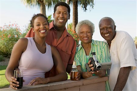 Senior couple and mid-adult couple, senior woman holding camcorder, portrait. Stock Photo - Premium Royalty-Free, Code: 694-03318131