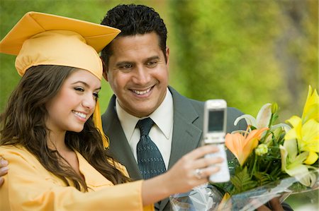Diplômé et photo prise père avec téléphone cellulaire à l'extérieur Photographie de stock - Premium Libres de Droits, Code: 694-03318783