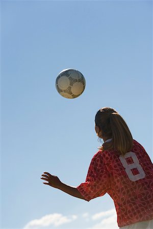 Girl (13-17) heading soccer ball, back view Stock Photo - Premium Royalty-Free, Code: 694-03318874