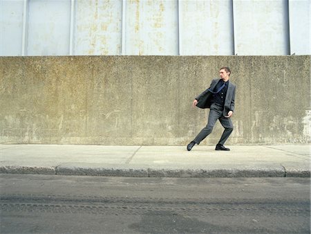 people running scared - Teenager in suit running on street, looking back Stock Photo - Premium Royalty-Free, Code: 694-03326056