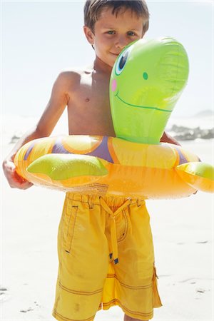 Boy Playing With Float Tube on Beach Stock Photo - Premium Royalty-Free, Code: 694-03326361