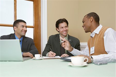 Three business men talking at desk Stock Photo - Premium Royalty-Free, Code: 694-03327676