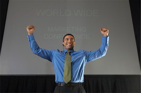 Business man speaking at conference, arms raised Stock Photo - Premium Royalty-Free, Code: 694-03327688