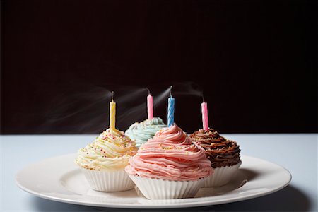 simsearch:630-02219911,k - Colourful cupcakes with blowed birthday candles on plate Stock Photo - Premium Royalty-Free, Code: 694-03328124