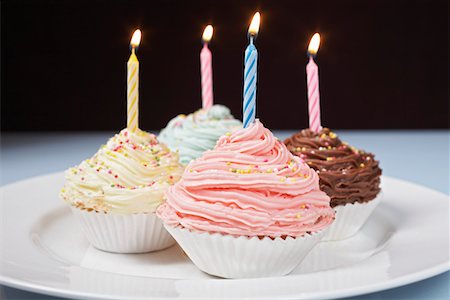 simsearch:630-02219911,k - Pastel cupcakes with birthday candles on plate Stock Photo - Premium Royalty-Free, Code: 694-03328123