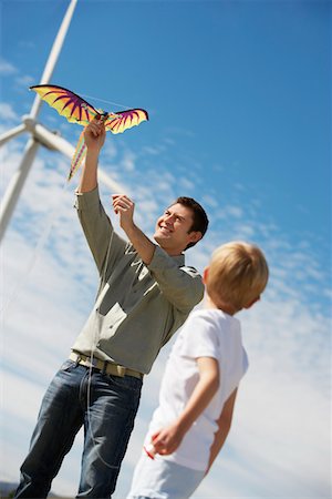 family smile kite - Father and son (7-9) playing with kite at wind farm Foto de stock - Sin royalties Premium, Código: 694-03328220