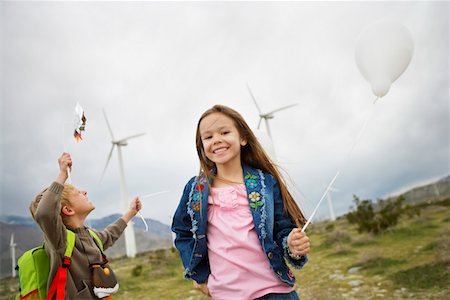 Boy and girl (5-9) playing with balloons at wind farm Foto de stock - Sin royalties Premium, Código: 694-03328234