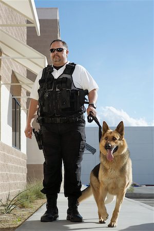 Security guard with dog on patrol Stock Photo - Premium Royalty-Free, Code: 694-03328321