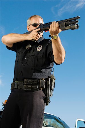 Police Officer Aiming Shotgun Stock Photo - Premium Royalty-Free, Code: 694-03328454
