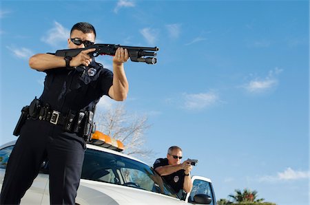 Police Officer Aiming Shotgun Stock Photo - Premium Royalty-Free, Code: 694-03328450
