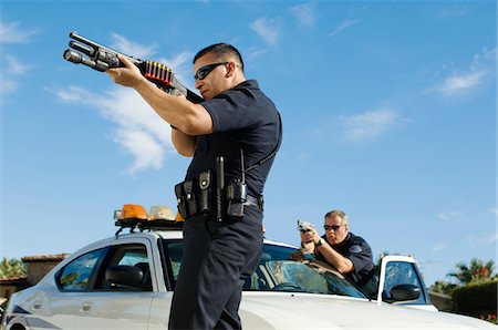 Police Officer Aiming Shotgun Stock Photo - Premium Royalty-Free, Code: 694-03328451
