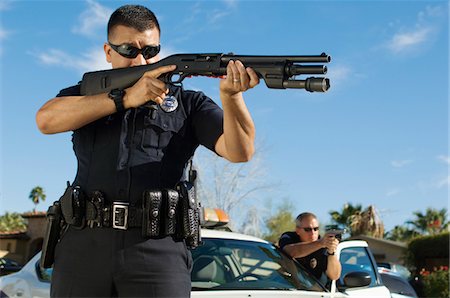 Police Officer Aiming Shotgun Stock Photo - Premium Royalty-Free, Code: 694-03328452