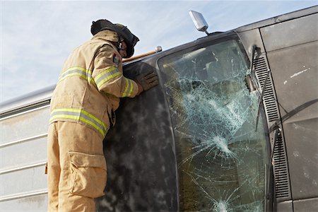 firefighter rescue truck - Firefighter looking into crashed car Stock Photo - Premium Royalty-Free, Code: 694-03328537