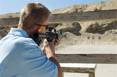 Man aiming machine gun at firing range Stock Photo - Premium Royalty-Free, Code: 694-03328574