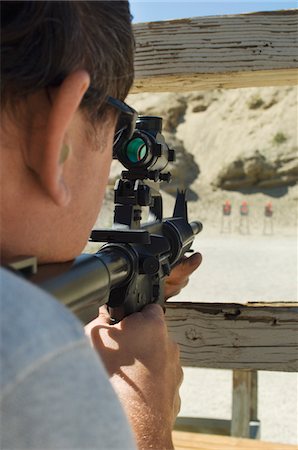 Man aiming rifle at firing range Stock Photo - Premium Royalty-Free, Code: 694-03328577