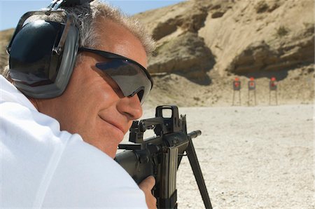 Man aiming machine gun at firing range Stock Photo - Premium Royalty-Free, Code: 694-03328594