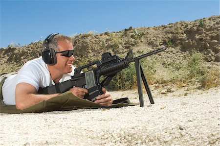 Man aiming machine gun at firing range Stock Photo - Premium Royalty-Free, Code: 694-03328595