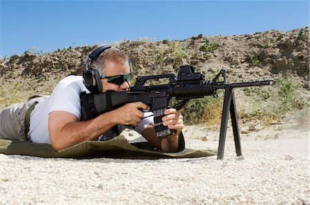 Man aiming machine gun at firing range Stock Photo - Premium Royalty-Free, Code: 694-03328597