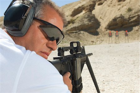 Man aiming machine gun at firing range Stock Photo - Premium Royalty-Free, Code: 694-03328592