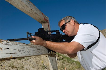 simsearch:700-00546343,k - Man aiming rifle at firing range Stock Photo - Premium Royalty-Free, Code: 694-03328611