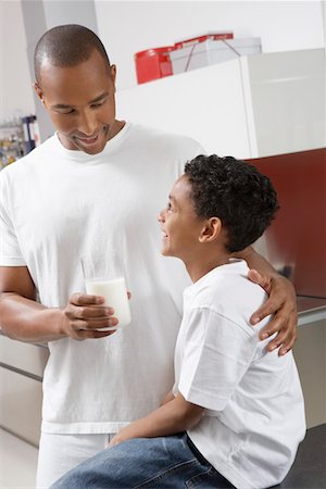 Father holding glass of milk, embracing son (7-9) indoors Foto de stock - Sin royalties Premium, Código: 694-03329110