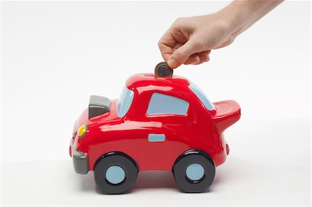 simsearch:693-06021323,k - Hand Putting Money in Car Shaped Piggy Bank Stock Photo - Premium Royalty-Free, Code: 694-03331489