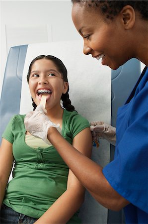 Female nurse checking girls tongue in hospital Foto de stock - Sin royalties Premium, Código: 694-03331507