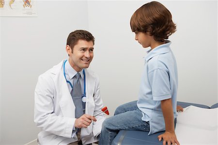 simsearch:694-03331631,k - Mid-adult doctor examining boy with reflex hammer Stock Photo - Premium Royalty-Free, Code: 694-03331638