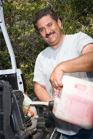 Portrait of man pouring fuel into lawn mower Stock Photo - Premium Royalty-Free, Code: 694-03331988