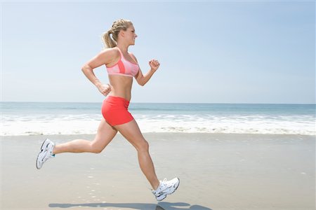 Woman jogging along beach Stock Photo - Premium Royalty-Free, Code: 694-03332368