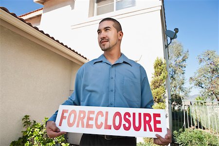 Man holding sign outside house Stock Photo - Premium Royalty-Free, Code: 694-03332580